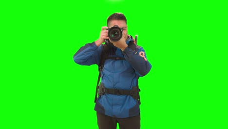 adult man with backpack taking photos in green studio