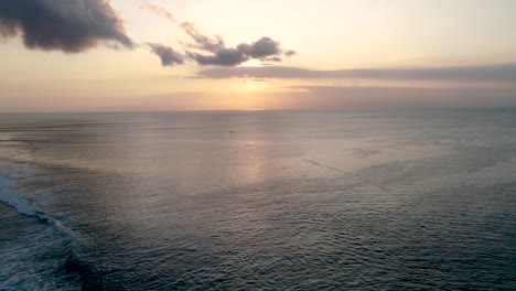 Aerial-Shot-Fly-Over-Blue-Ocean-And-Tropical-Beach-Cloudy-Sunset-Dawn-at-Bali-Indonesia-Southeast-Asia-4K