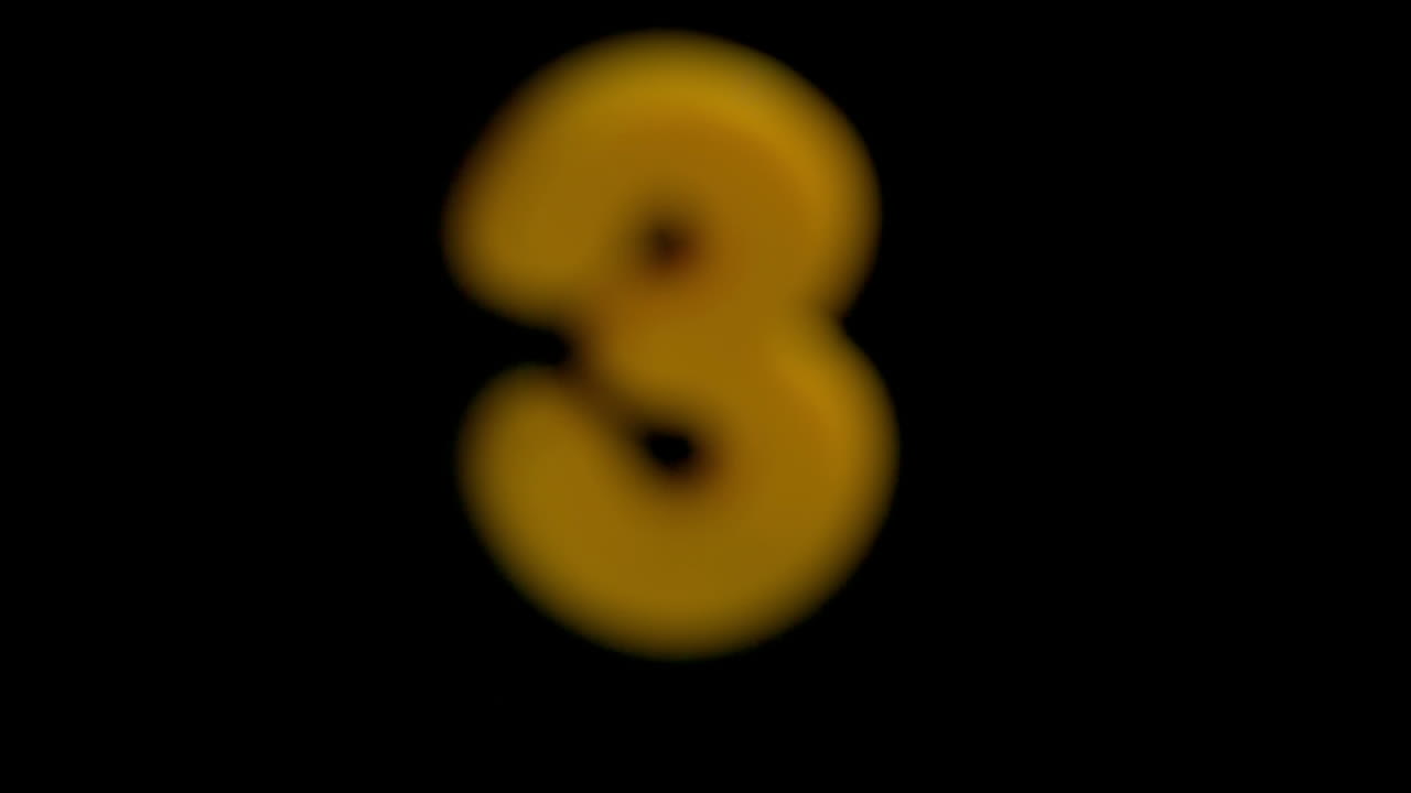The number three coming into focus on black background