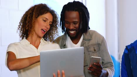 Business-executives-discussing-over-digital-tablet-and-laptop