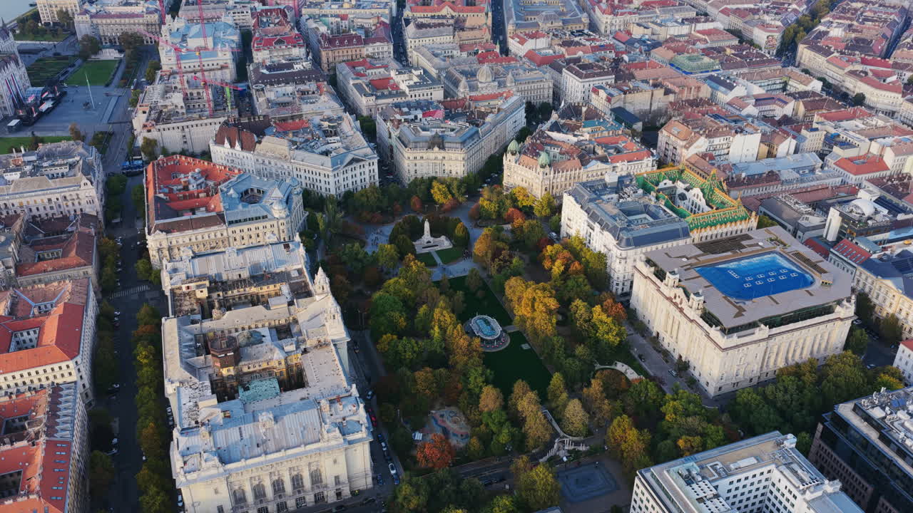Top-down drone shot of Szabadság Square surrounded by ornate architecture and autumn-colored trees