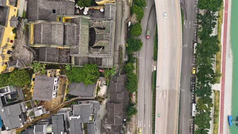 top-down aerial view of chongqing, china, a traditional chinese guild hall beside modern road traffic. a striking contrast between historical architecture and urban infrastructure.