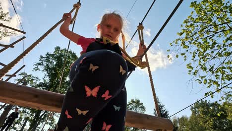 Niña-Feliz-Jugando-En-La-Atracción-De-Tarzán-En-El-Patio-De-Recreo-Del-Parque-De-Atracciones