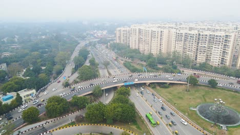 aerial drone shot showing an aerial perspective of delhi’s highways and flyovers, packed with vehicles moving in different directions.