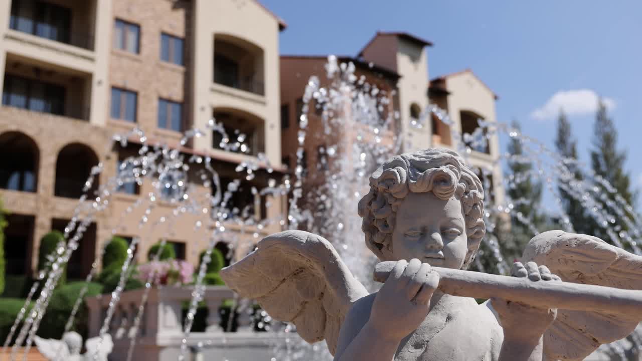 Estatua de querubín tocando la flauta en una fuente de agua