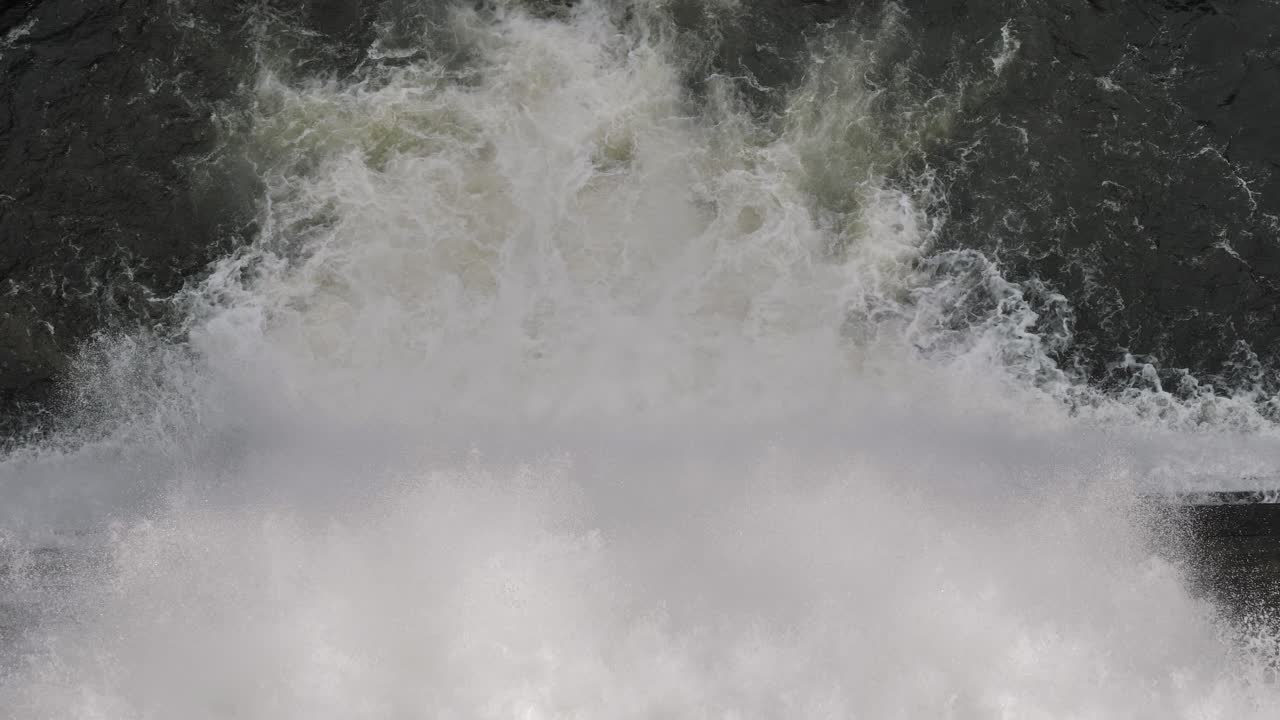 Top down tight view of water flowing through the Hinze Dam overflow due to ongoing heavy rains in the Gold Coast Hinterland