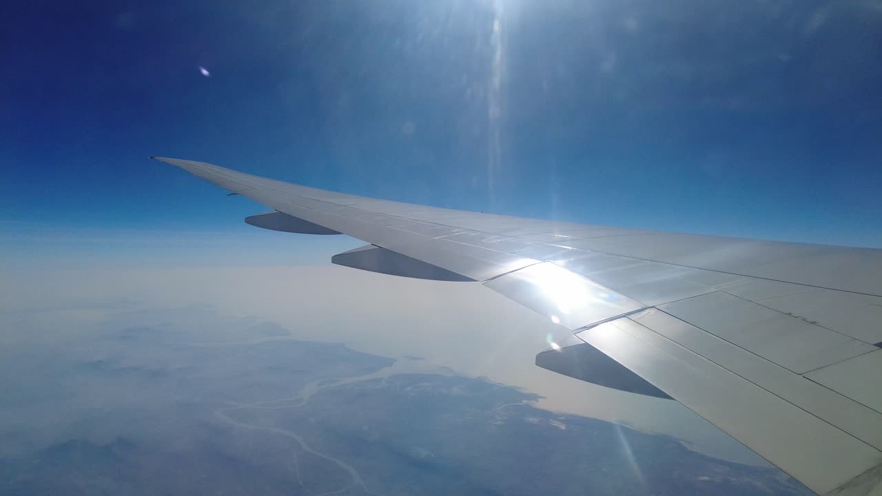 Vinge af fly der flyver over skyerne