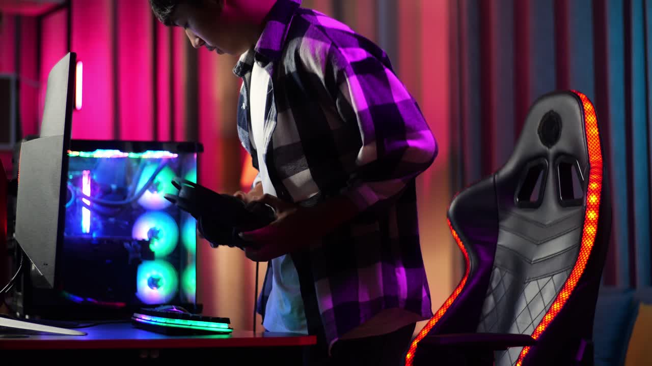 adolescente asiático sentado y comienza a jugar videojuegos en la computadora