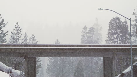 a car passes over an overpass in the morning as it snows