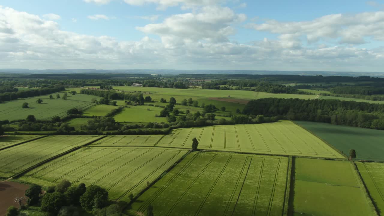 Gale wind blowing across green crop fields causing waves in countryside from Aerial view