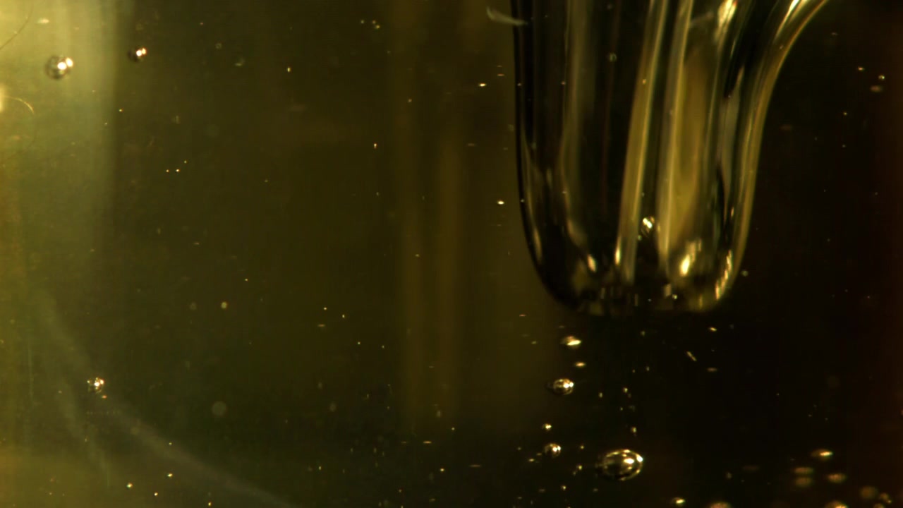 Close-up of Golden Bubbles Floating in Viscous Liquid