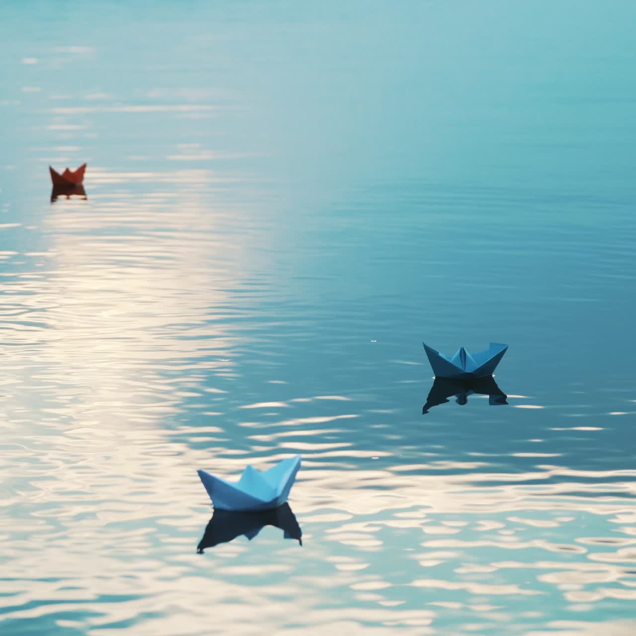 Paper boats floating in the river. Beautiful summer sunset. Origami.