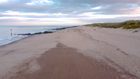 Aerial-shot,-traveling-across-a-beach-to-reveal-the-beautiful-coastline-at-Horsey-Gap