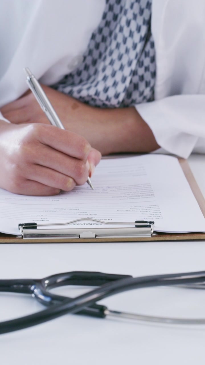 Medico che scrive appunti medici su una cartella clinica in clinica.