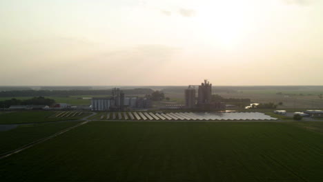 Granja-De-Alta-Tecnología:-Campo-De-Hierba-Y-Silos-Agrícolas-Con-Un-Campo-De-Paneles-Solares-De-Drones-Aéreos