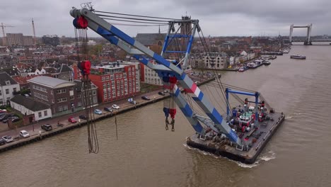 El-Brazo-Mecánico-De-La-Grúa-Industrial-Se-Extiende-Con-Precisión-Mientras-Navega-A-Lo-Largo-Del-Río.