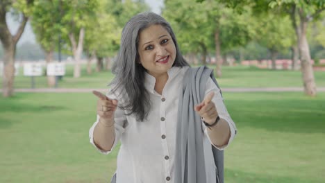 Happy-Indian-mother-talking-to-someone-in-park