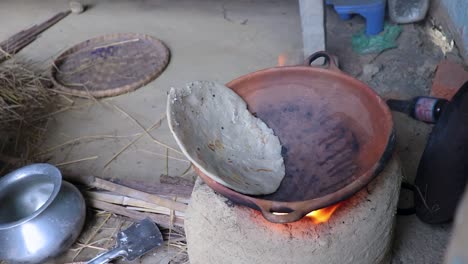 rice floor bread making in traditional soil vessels at wood fire from different angle