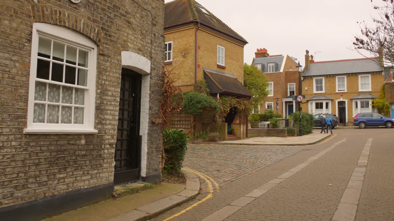 Billede af en smal gade med huse i Twickenham-arkitektur i London, England på en overskyet dag.