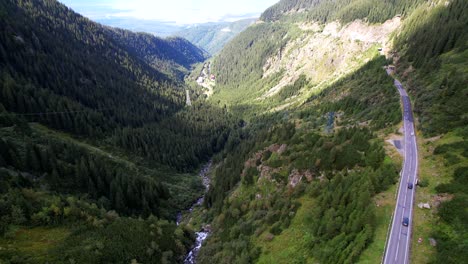 drone descends above transfagarasan serpentine road showcasing mountain river rushing through valley