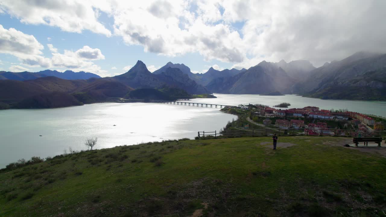 Aerial reveal of family in a swing playing with their child at the viewpoint in Ria&ntilde;o, a village in Le&oacute;n, Spain on the shore of a large reservoir in the Cantabrian mountains