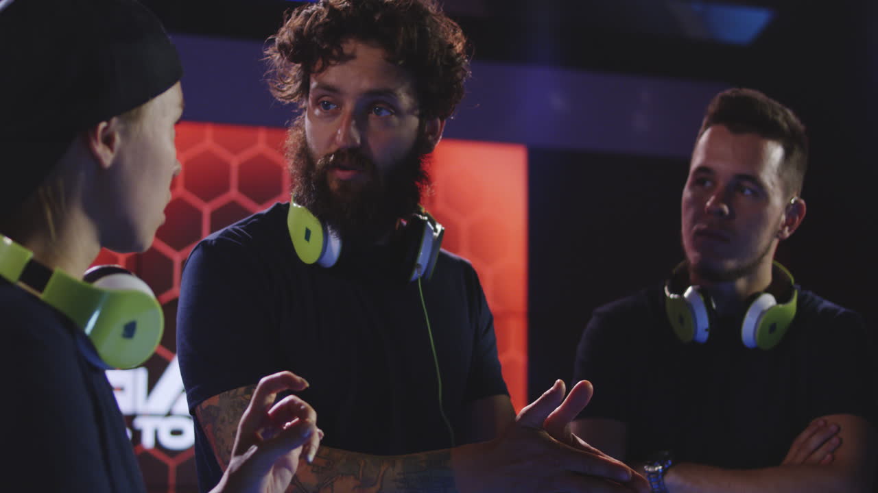 Team of Paintball Players Discussing the Past Game Happy Group of Paintball Players with Guns after Match on Paintball Playing Field