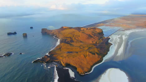 aerial cinematic drone from above stunning sunrise early winter at black sand beach apostles fire and ice ocean next to dyhrolaey lighthouse reynisfjara iceland