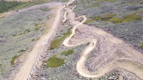 young man biking downs curving on a dowhill biking track in lapland finland