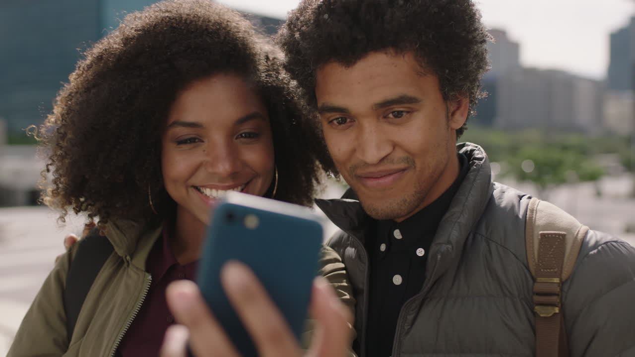 retrato de una joven pareja afroamericana posando tomando fotos usando un teléfono inteligente disfrutando de viajar juntos fondo urbano