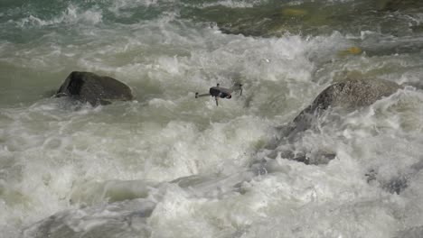 drone mavic 2 pro flying above powerful river stream falls, slow motion, day