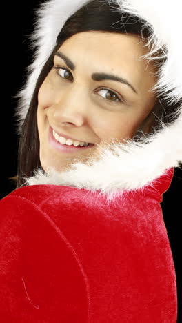 una mujer bonita sonriente posando en un traje sexy de papá noel.