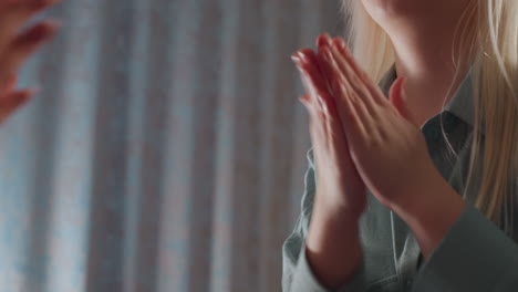 close up of children clapping hands playfully with unseen partners indoors, expressing joy and connection in relaxed setting with curtain backdrop