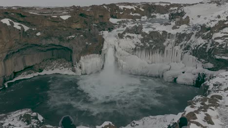 tourist photographers at picturesque aldeyjarfoss waterfall in iceland - aerial