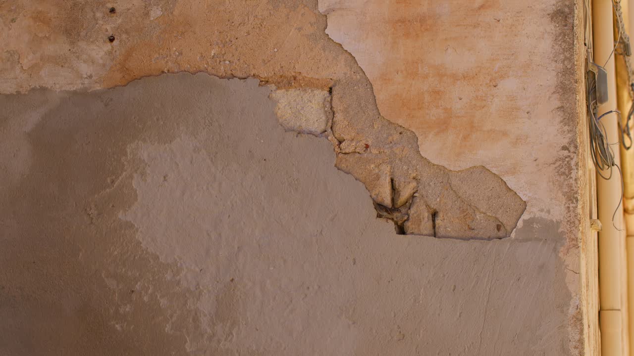 Old wall with weathered texture in Scopello city center, Sicilia, Italy