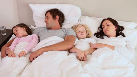 Family-sleeping-in-a-bed