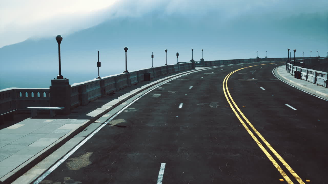 Curved road along the coast shrouded in fog near the ocean at dawn