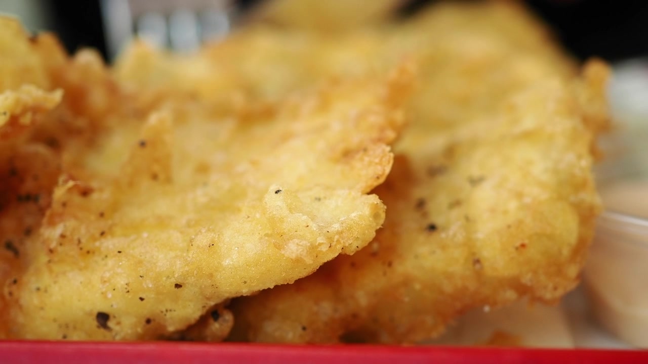 Primer plano de filetes de pescado frito crujientes en una bandeja de servir