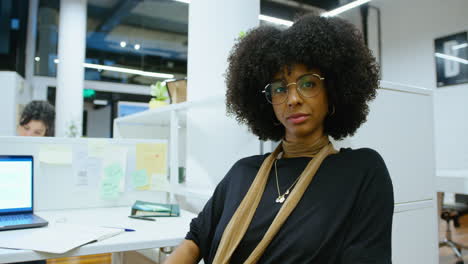 portrait of young african-american businesswoman posing at office cubicle