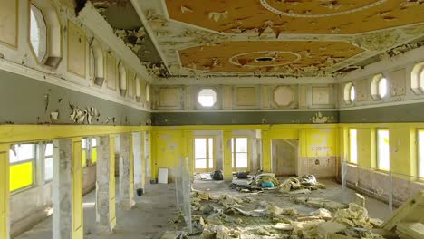 vuelo de aviones no tripulados a través de un salón de baile amarillo erosionado por el tiempo