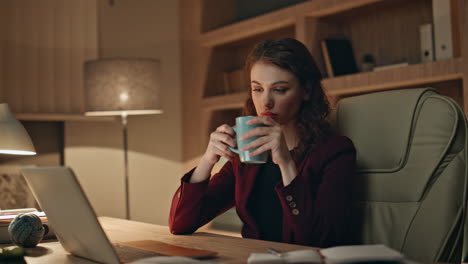 tired freelancer enjoy coffee working overtime at office laptop evening close up