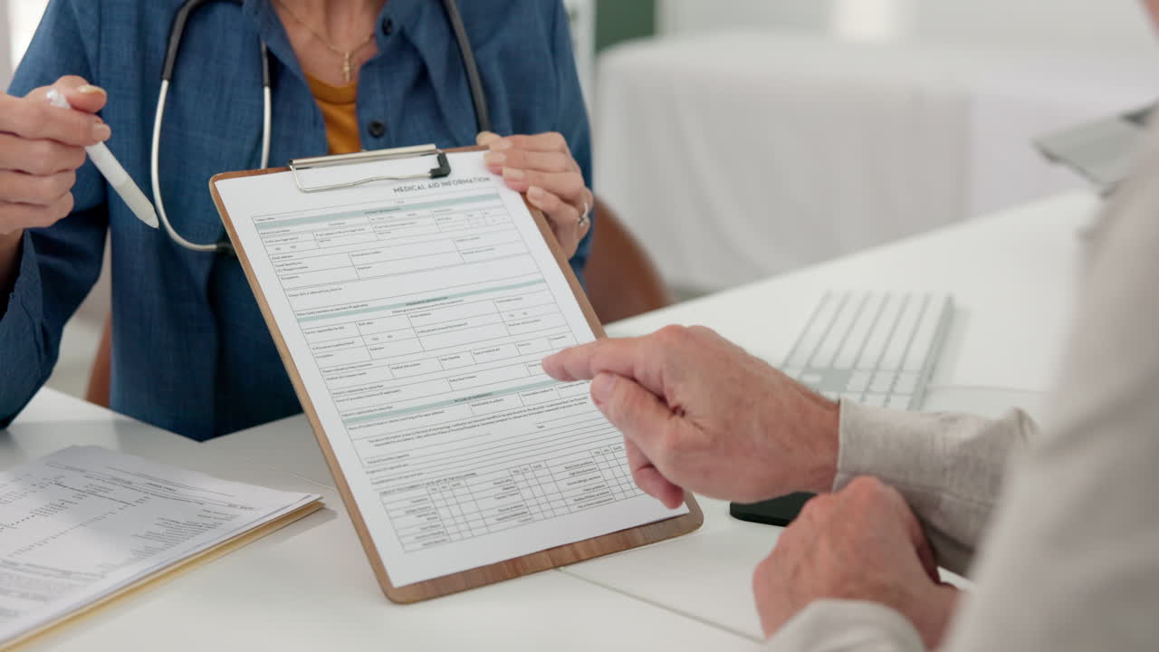 Médico explicando formulario de información médica a paciente durante consulta.