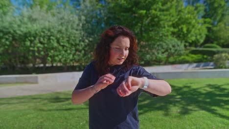 mujer comprobando el reloj inteligente en el parque
