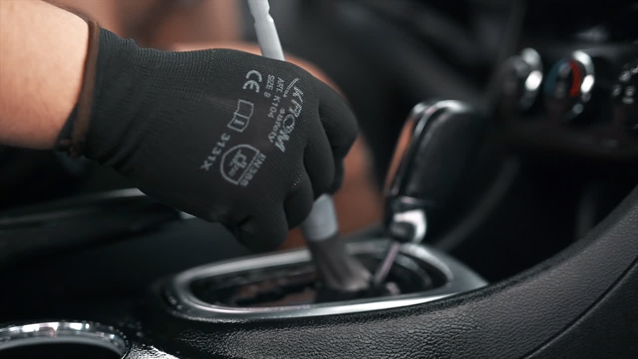 Working cleaner at car wash. Cleaning the transmission box using a brush and chemical solution. Slow motion