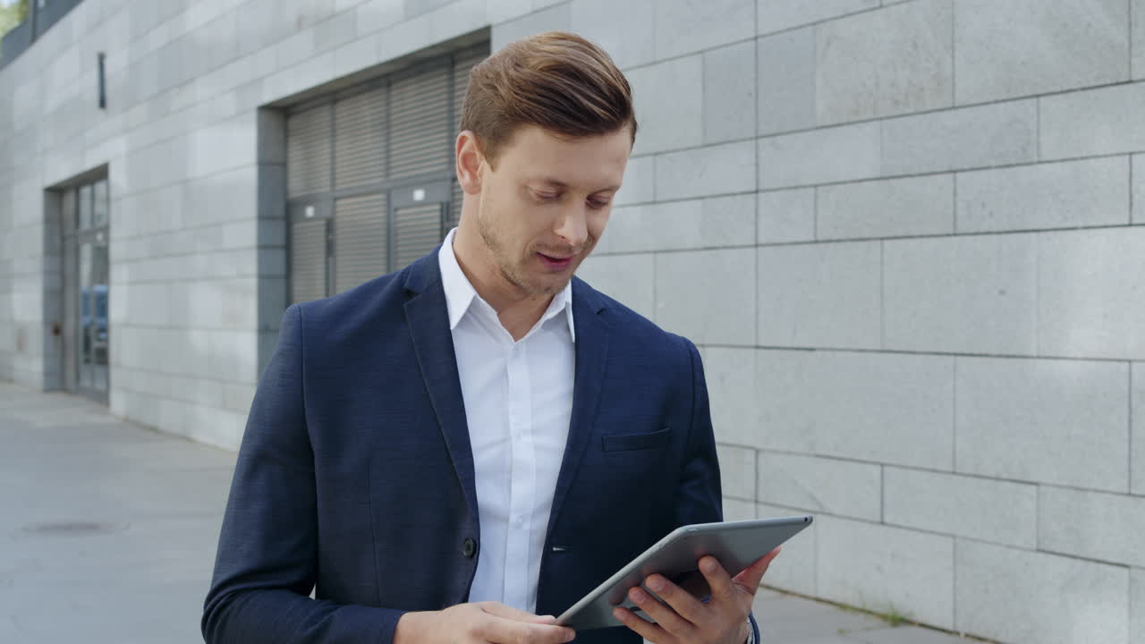 Businessman receiving good news on tablet. Professional celebrating victory