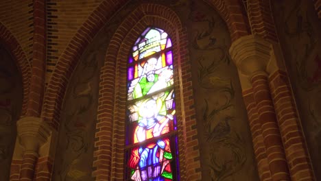 stained glass window in church, downward tilt reveal up shot