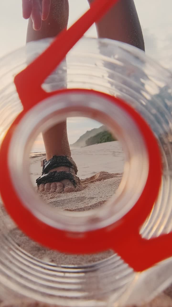 Young caucasian woman volunteer removes plastic bottles washed up on shore