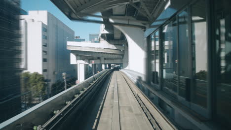 Yurikamome-Zug,-Der-Tagsüber-Auf-Der-Eisenbahn-In-Tokio,-Japan,-Beschleunigt