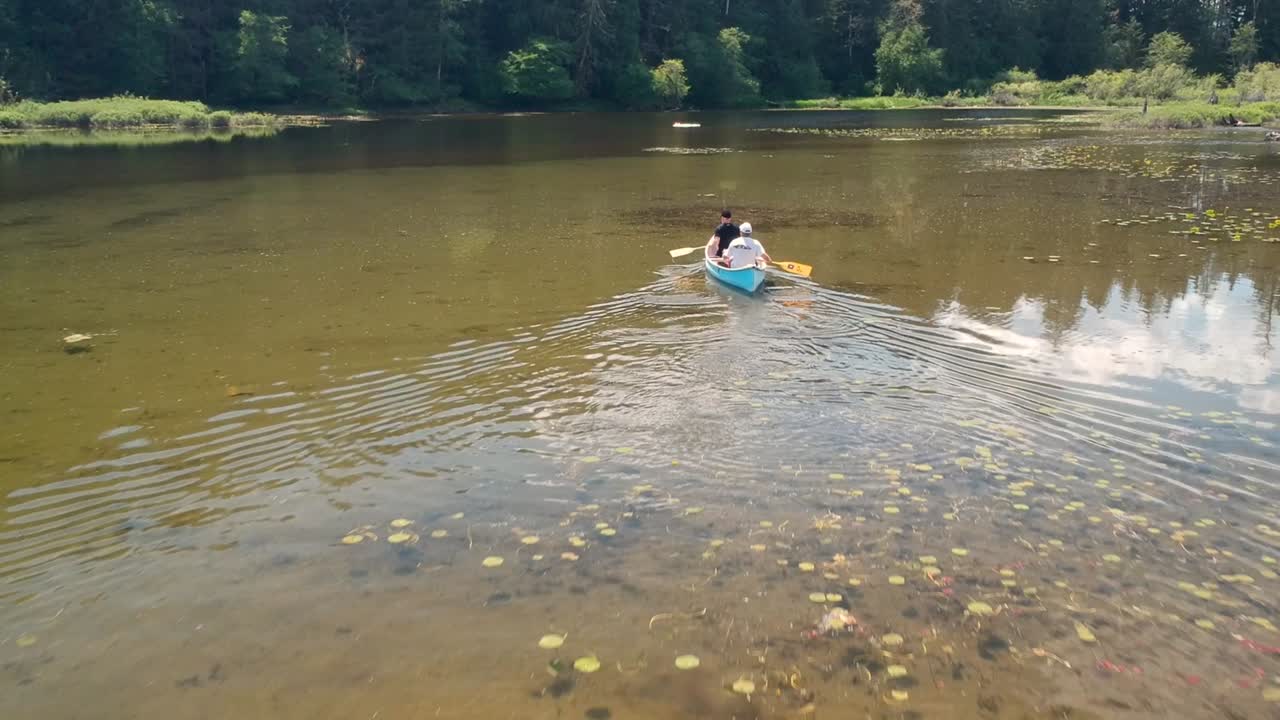 백합이 있는 호수에서 카누를 타는 두 남자