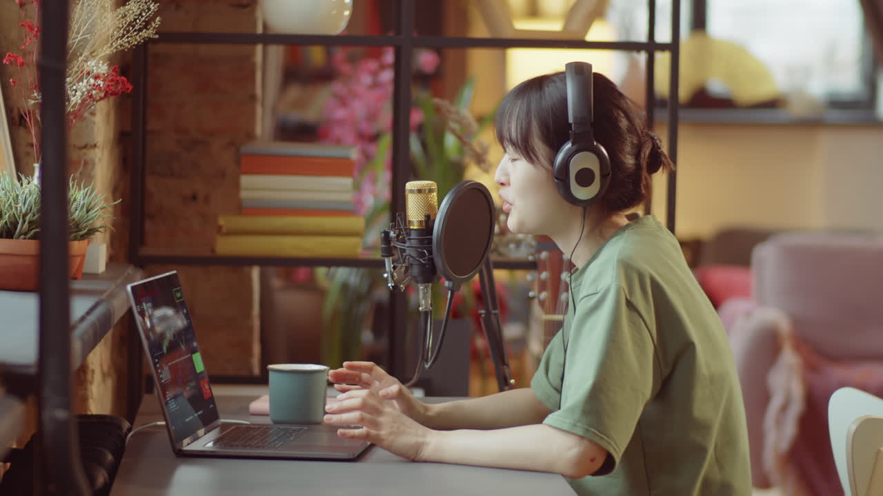mujer asiática grabando podcast en casa