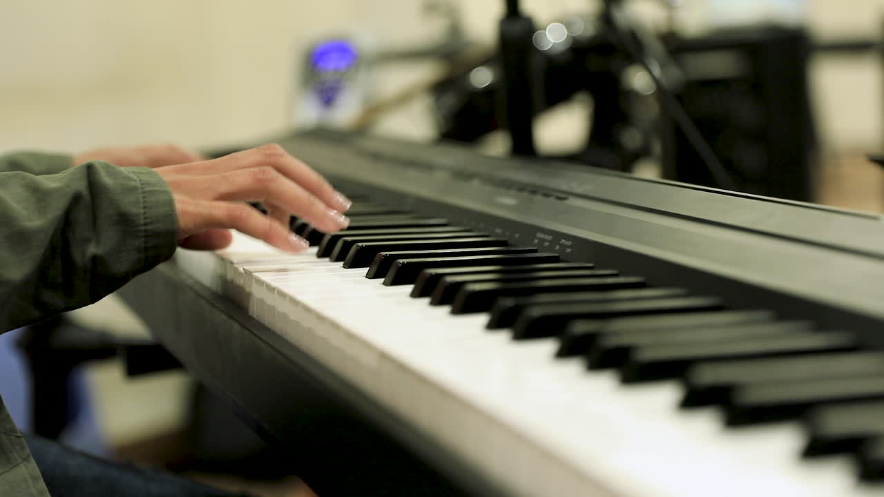 A girl playing the piano in the studio to the side